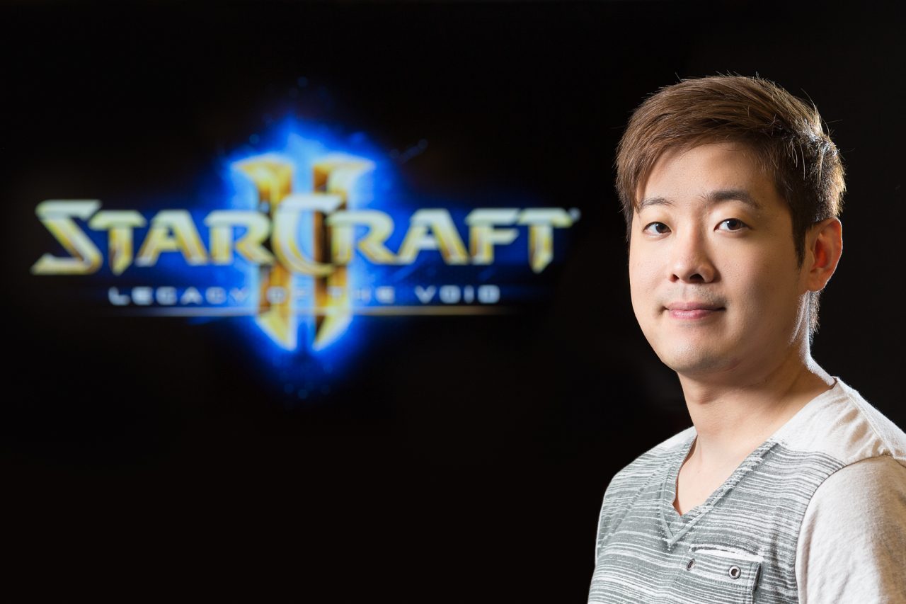Professional portrait of Blizzard Entertainment staff with the StarCraft II logo in the background.