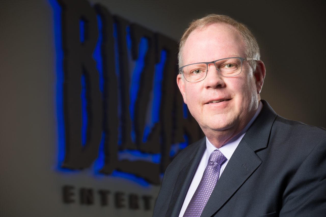 Professional headshot of a Blizzard Entertainment executive with the Blizzard logo behind them.